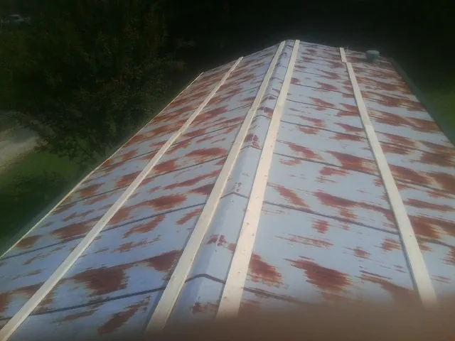 Rusted metal roof panels with new wood purlins before replacement — Storm Damage Roof Repair in Woodlyn by Roofing Brothers