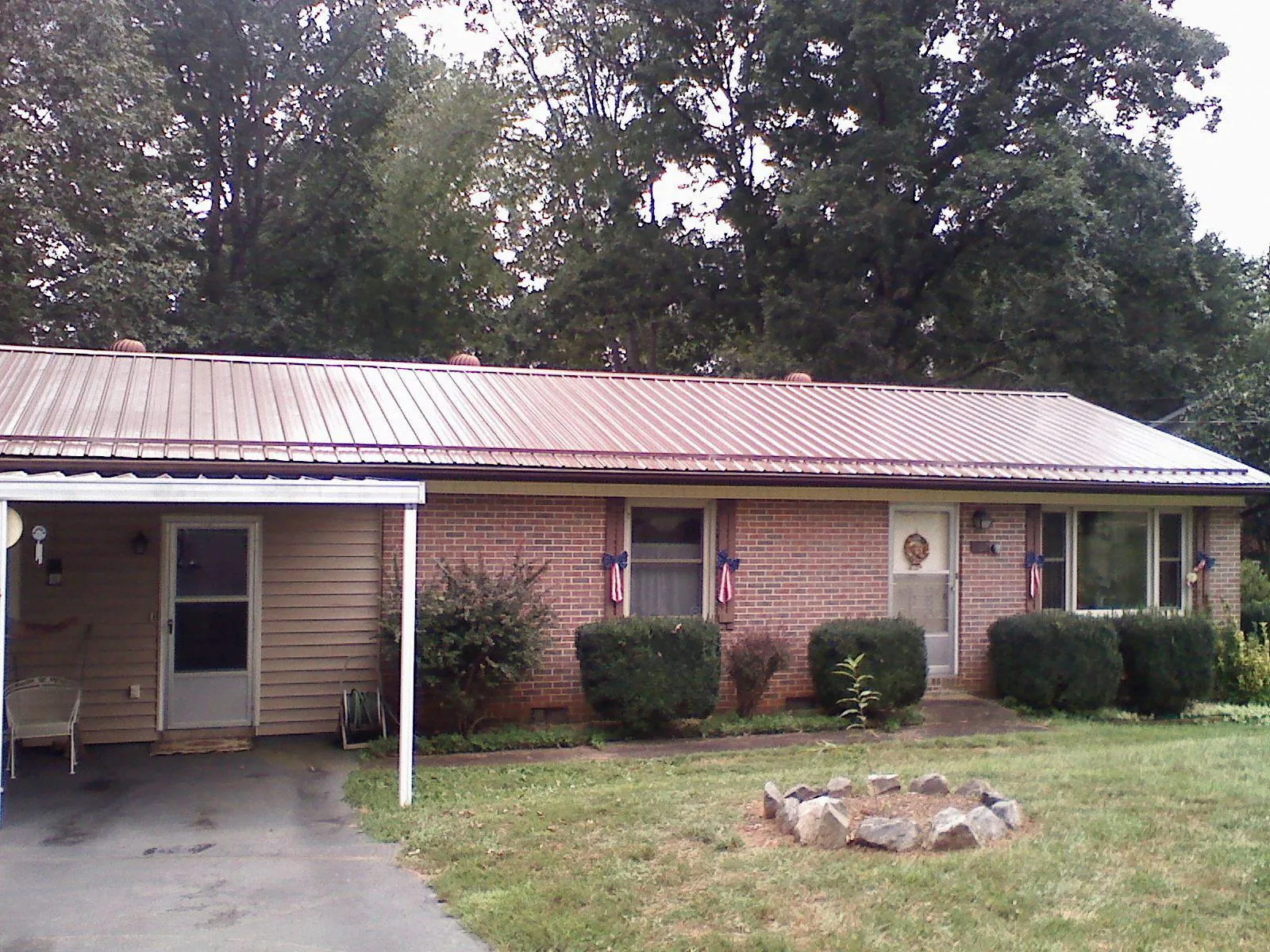 Bronze metal roof and carport on a brick ranch home — Roof Repair work by our crew in Woodlyn
